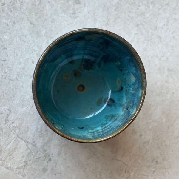Drippy Blue ceramic planter on a light stone surface