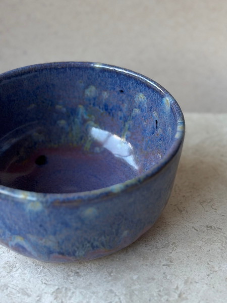 Blue ceramic bowl on a light gray surface with a neutral background