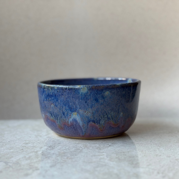 Blue ceramic bowl on a textured surface with a neutral background